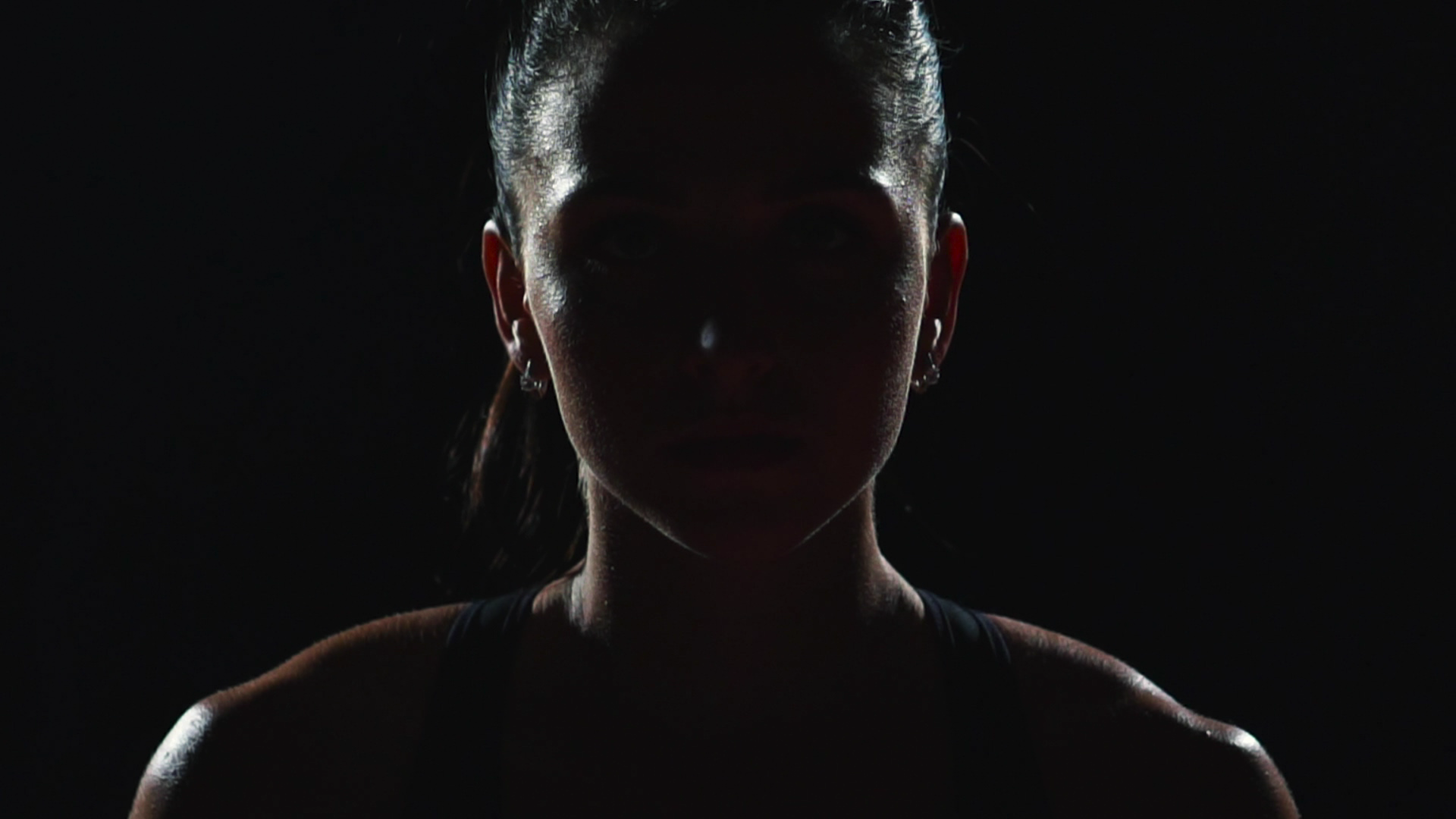 Dramatic lighting of female athlete representing practice of mental skills