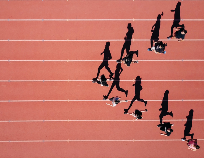 image of a coral colored track with shadow images of runners in a V formation running on the track